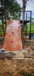 a climbing wall in a park with trees at Gaharu glamping park in Jerantut