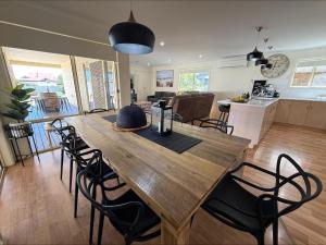 a kitchen and dining room with a wooden table and chairs at Sea Change Coobowie in Coobowie