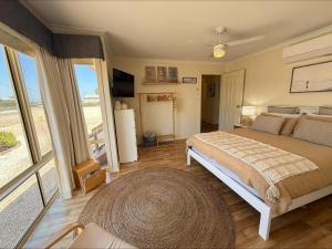 a bedroom with a large bed and a large window at Sea Change Coobowie in Coobowie