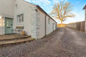 a house with a bench next to a dirt road at 3 Bed in Caldbeck oc-h30704 in Caldbeck
