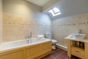 a bathroom with a tub and a toilet and a sink at 4 Bed in Caistor oc-t30831 in Caistor +20 photos