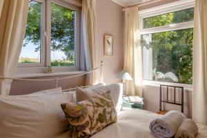 a bedroom with a bed and two large windows at 2 Bed in Kettlestone oc-t32268 in Little Snoring