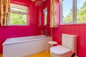a pink bathroom with a tub and a toilet at 2 Bed in Kettlestone oc-t32268 in Little Snoring +22 photos