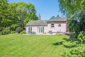 a pink house with a large lawn in front of it at 2 Bed in Kettlestone oc-t32268 in Little Snoring