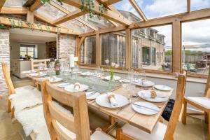 a dining room with a long table and a glass ceiling at 6 Bed in Llanwern oc-w31947 in Brecon