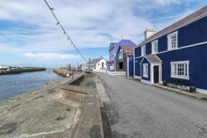 a street with blue buildings next to the water at 2 Bed in Aberaeron oc-bow173 in Aberaeron