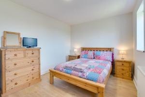 a bedroom with a bed and a dresser with a tv at 2 Bed in Gower oc-hh487 in Penclawdd