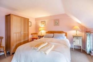 a bedroom with a large white bed with two towels on it at 4 Bed in Arne oc-wy343 in Arne