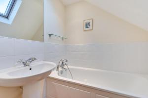 a white bathroom with a sink and a bath tub at 1 Bed in Aldeburgh oc-sld in Aldeburgh