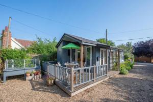 a small blue house with a green umbrella at 1 Bed in Waldringfield oc-thstu in Waldringfield