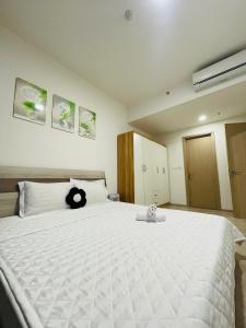 a bedroom with a large bed with a black cat on it at 2 Bedrooms Masterise Center Point C Vinhomes Grand Park in Long Bình +24 photos