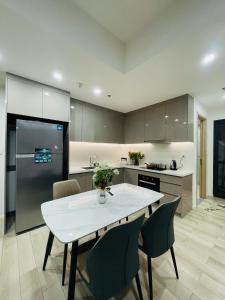 a kitchen with a table and chairs and a refrigerator at 2 Bedrooms Masterise Center Point C Vinhomes Grand Park in Long Bình