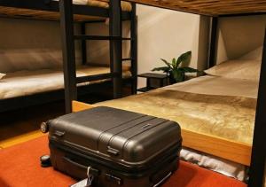 a suitcase sitting on the floor in a room with bunk beds at Hostel Cangas Backpackers in Cangas de Morrazo
