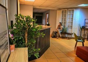 a woman sitting on a bench in an office lobby at Hostel Cangas Backpackers in Cangas de Morrazo