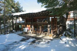 a building in the snow with snow on the ground at Shibu Tatunokan in Chino