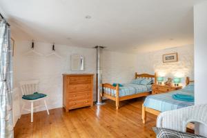 a bedroom with two twin beds and a wooden floor at 2 Bed in Chideock oc-g32451 in Chideock