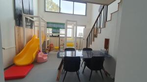 a dining room with a table and a slide at Geoje Theview Kids Poolvilla in Geoje