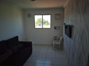 a living room with a couch and a television at Apartamento Duplex em Jacumã in Conde