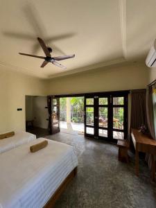 a bedroom with two beds and a ceiling fan at Teba junjungan cottages & villa in Ubud +163 photos