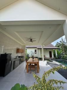 a patio with a table and a kitchen under awning at Teba junjungan cottages & villa in Ubud