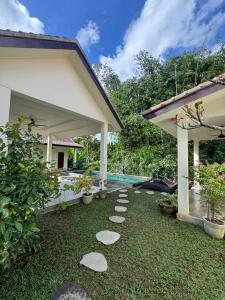 a garden with stepping stones in front of a house at Teba junjungan cottages & villa in Ubud