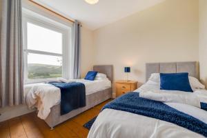 two beds in a bedroom with a window at 5 Bed in Llandovery oc-bow323 in Llangadog