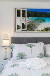 a bedroom with a bed with a palm tree picture on the wall at 1 Bed in Saltdean oc-bbidre in Saltdean