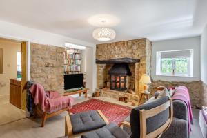 a living room with a stone wall with a fireplace at 2 Bed in Stoke Abbott oc-r31870 in Stoke Abbott