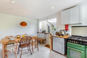 a kitchen with a green stove top oven next to a table at 2 Bed in Stoke Abbott oc-r31870 in Stoke Abbott
