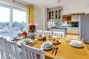 a kitchen and dining room with a wooden table with food at 4 Bed in Tenby oc-vv27177 in Manorbier