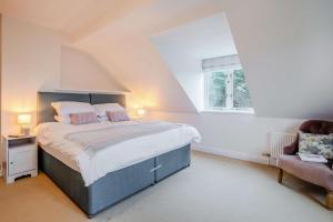 a bedroom with a large bed and a chair at 4 Bed in Tenby oc-vv27177 in Manorbier