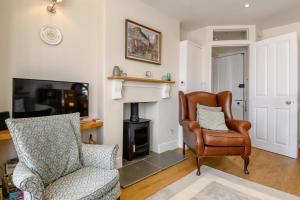 a living room with a chair and a fireplace at 2 Bed in Southwold oc-hdoubl in Southwold