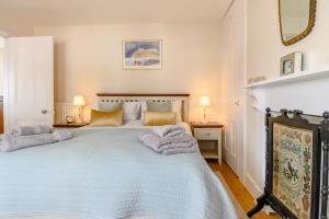 a bedroom with a large bed with towels on it at 2 Bed in Southwold oc-hdoubl in Southwold