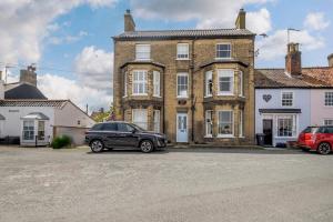a black car parked in front of a house at 2 Bed in Southwold oc-hdoubl in Southwold