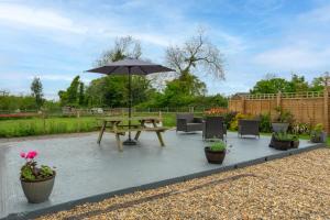 a picnic table with an umbrella in a garden at 4 Bed in Wrentham oc-hdress in Wrentham
