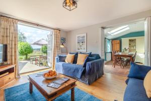 ein Wohnzimmer mit einem blauen Sofa und einem Tisch in der Unterkunft 3 Bed in Westleton Saxmundham oc-est in Westleton