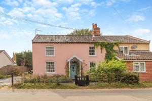 ein rosa Haus mit einem Zaun davor in der Unterkunft 3 Bed in Westleton Saxmundham oc-est in Westleton
