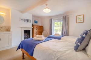 ein Schlafzimmer mit zwei Betten und einem Kamin in der Unterkunft 3 Bed in Westleton Saxmundham oc-est in Westleton