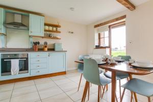 a kitchen with a wooden table and blue chairs at 2 Bed in Yoxford oc-hharro in Yoxford