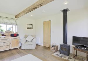 a living room with a wood stove and a chair at 2 Bed in Yoxford oc-hharro in Yoxford