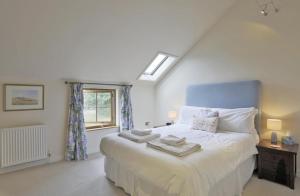 a bedroom with a bed with a blue headboard and a window at 2 Bed in Yoxford oc-hharro in Yoxford