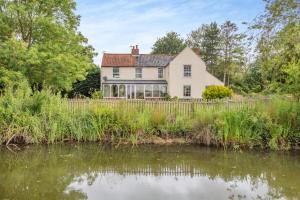 a white house with a pond in front of it at 3 Bed in Bungay oc-taf in Bungay