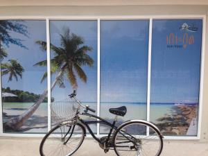 a bike parked in front of a building with a palm tree at Check In and Chill Out in Ban Laem Sok