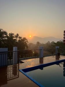 a view of the sunset from a hotel swimming pool at Munderi Green Mounts - Family Rooms with Pool, Wayanad, Kalpetta in Kalpetta