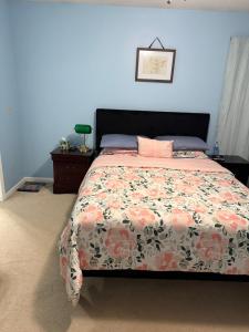 a bedroom with a bed with a floral comforter at Serenity in Statesboro
