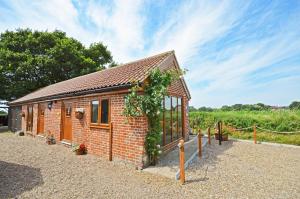 1 Bed in Acle oc-1256 في Cantley: مبنى صغير من الطوب تغطيه الكروم