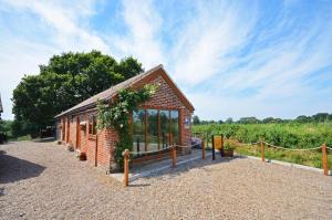 1 Bed in Acle oc-1256 في Cantley: مبنى صغير من الطوب به الكثير من النوافذ