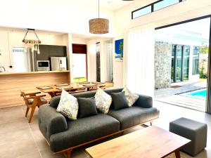 a living room with a couch and a table at Residence Azelina in Pointe aux Canonniers