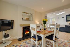 a dining room with a table and a fireplace at 2 Bed in Holt oc-2148 in Holt