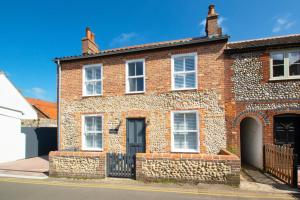 a red brick house with a black gate at 2 Bed in Holt oc-2148 in Holt